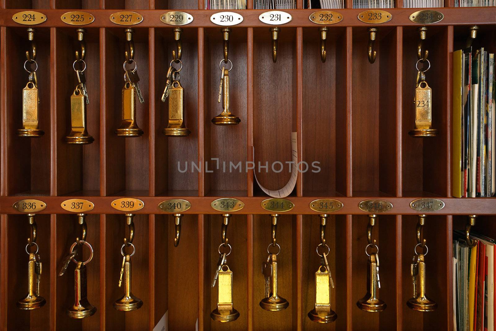 Vintage hotel front desk key rack. Focus on the top row of keys.
