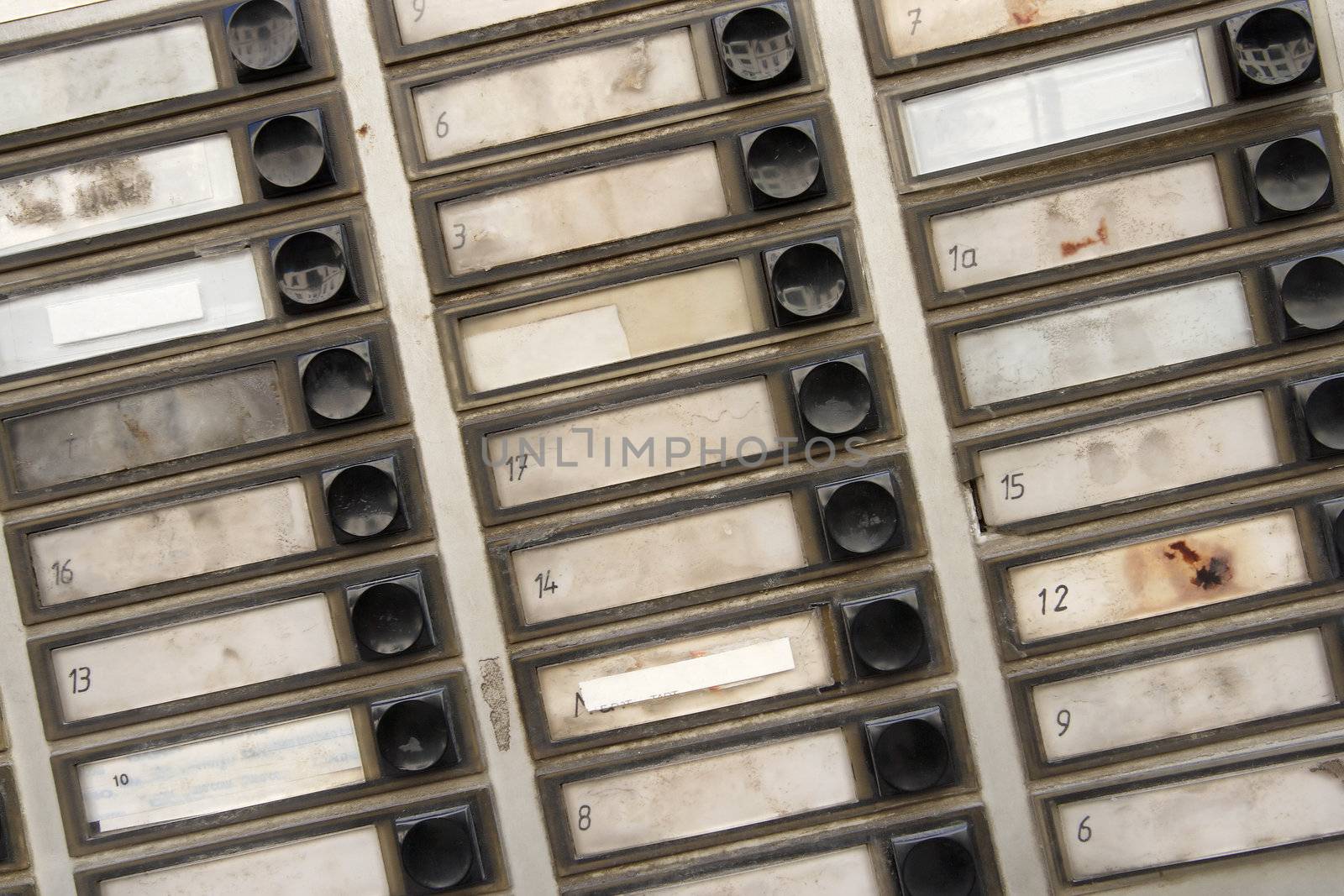 Background pattern of grungy old apartment buzzers - names removed.
