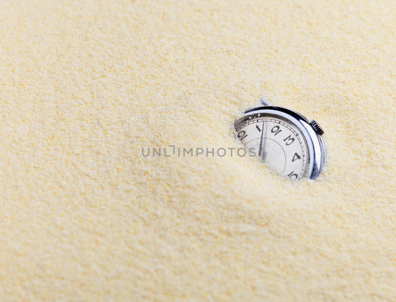 Composition on Zen garden - yellow sand, and old watch