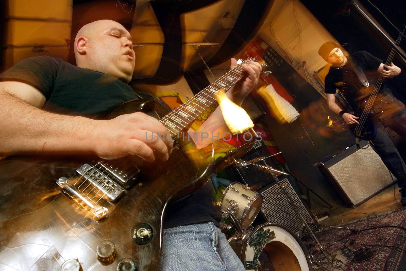 Heavy rock band playing. Shot with strobes and slow shutter speed to create lighting atmosphere and blur effects.
