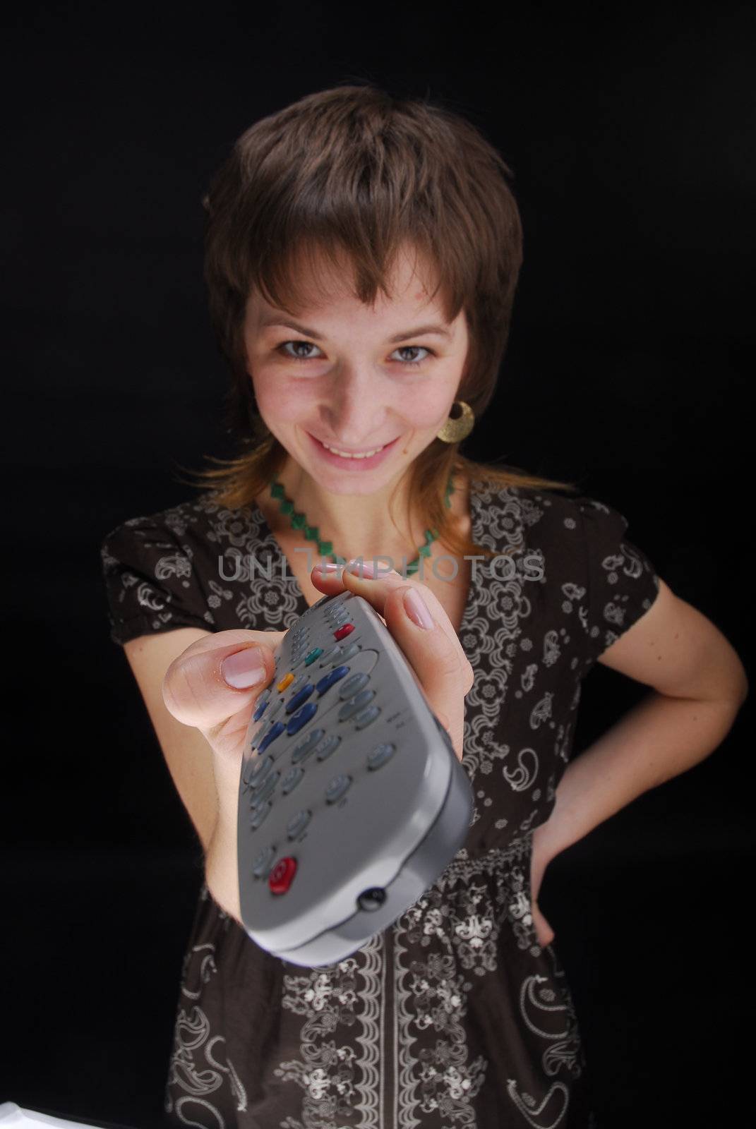 Young woman with tv remote control , isolated on black background