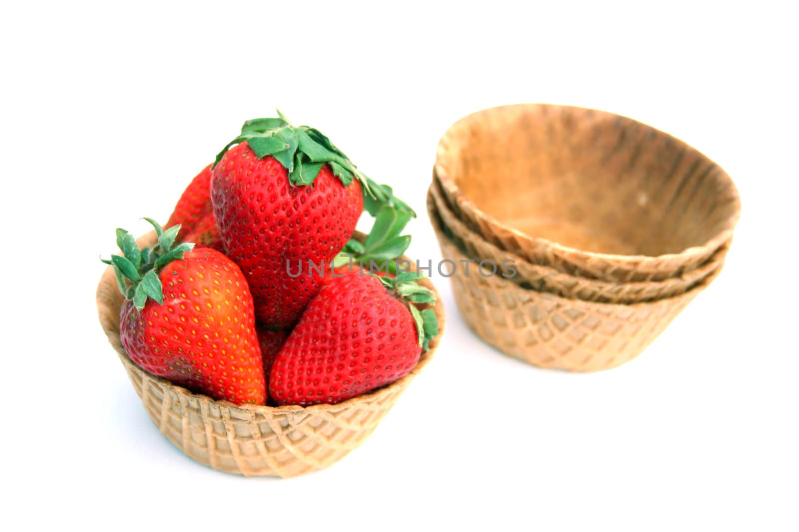 Fresh strawberries in a waffle cone bowl isolated on a white background.