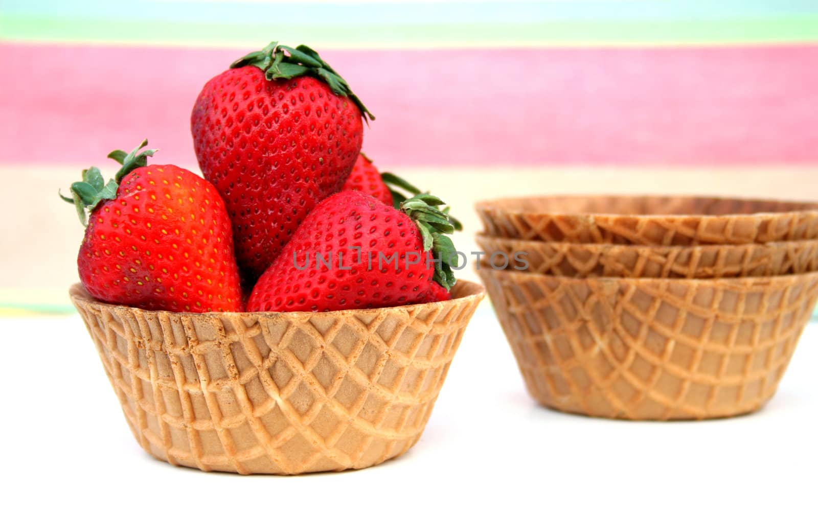 Strawberries in a waffle cone bowl.