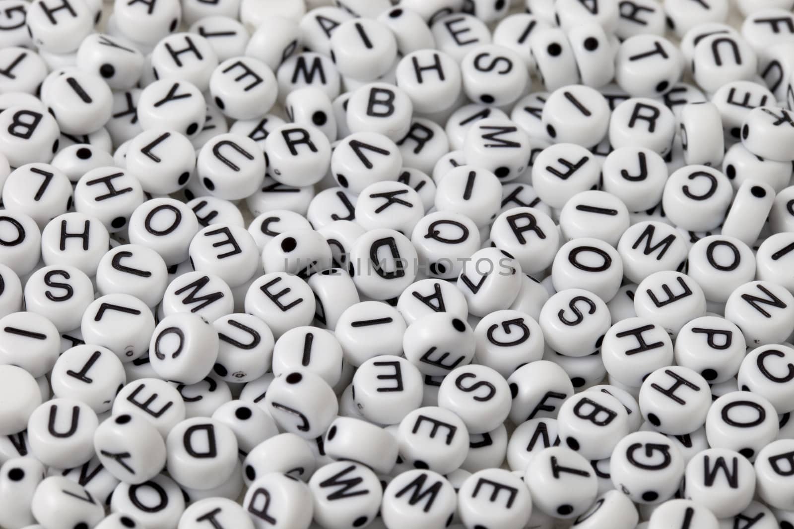 white plastic beads with black letters placed randomly