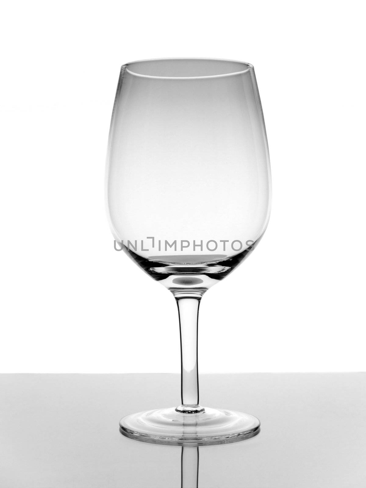A shot of an empty glass wine with reflection on white background.