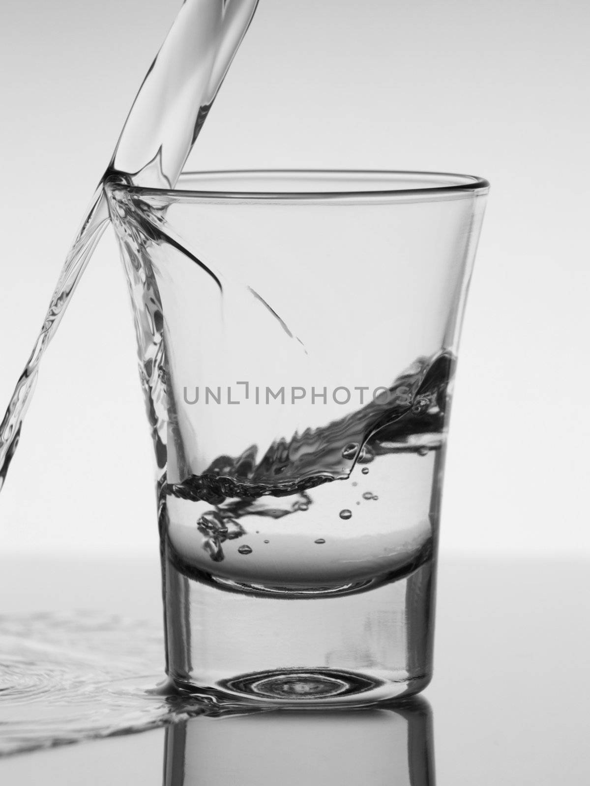 Pouring a shot of vodka. A conceptual image about the risk of  drinking excessively.