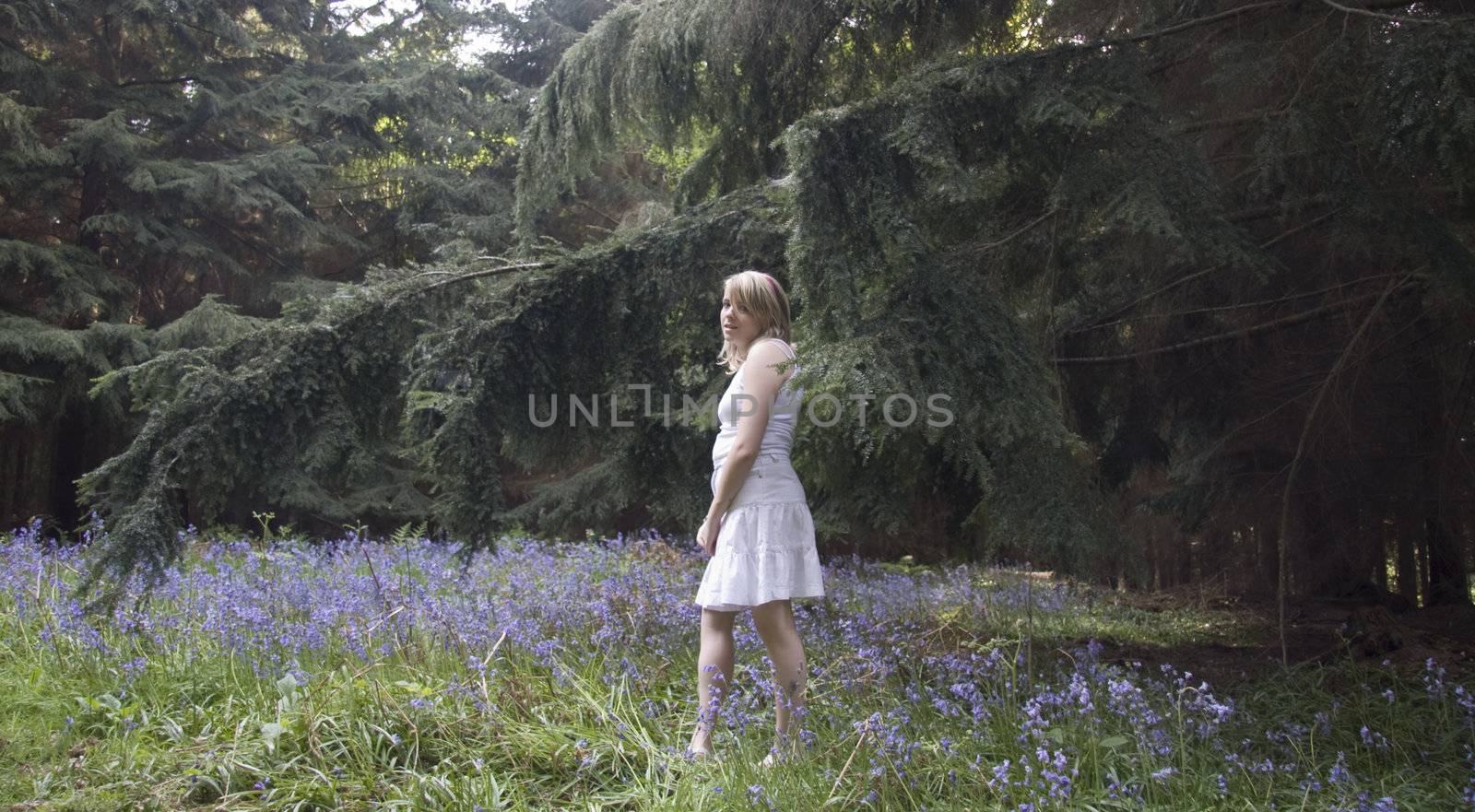 Prety teenage girl walking the bluebell wood.