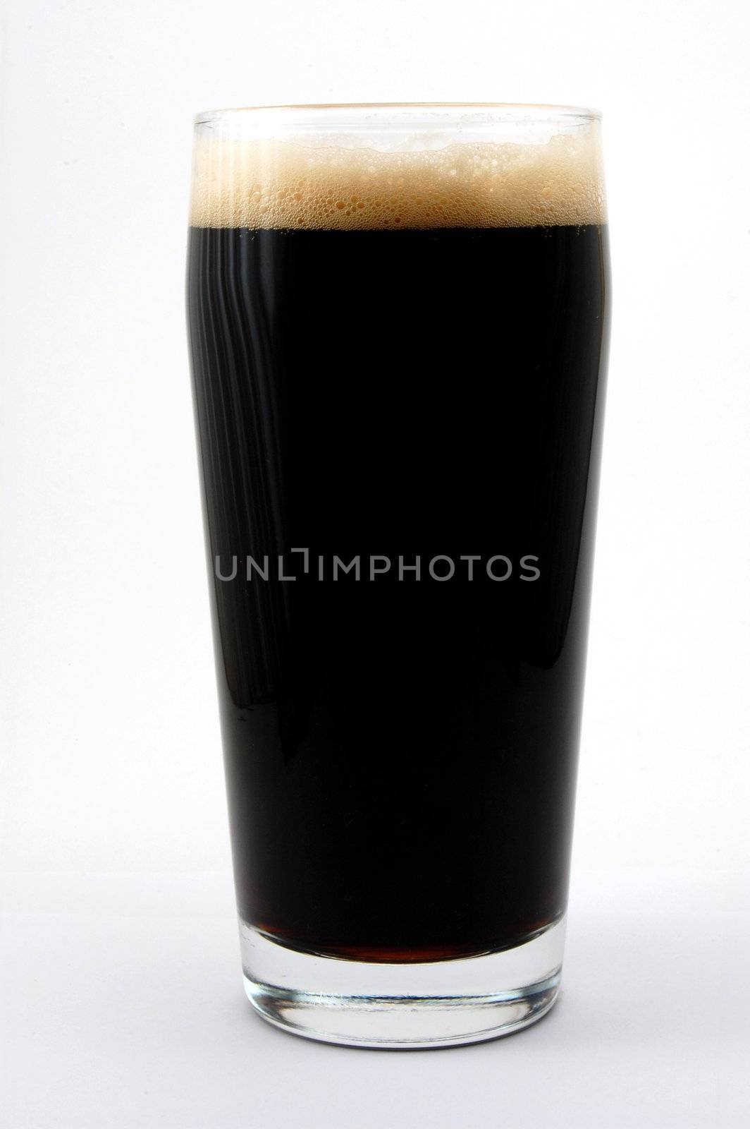 dark beer isolated on white background with foam