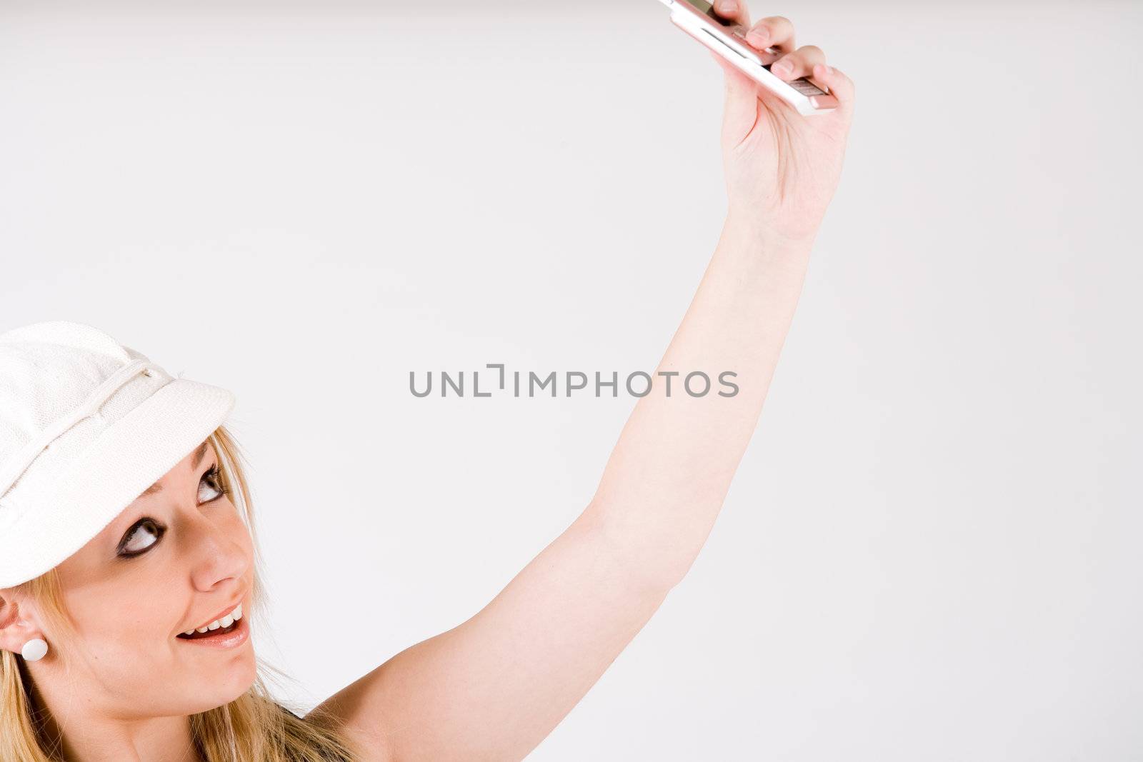 Young blond girl is busy with her cell phone