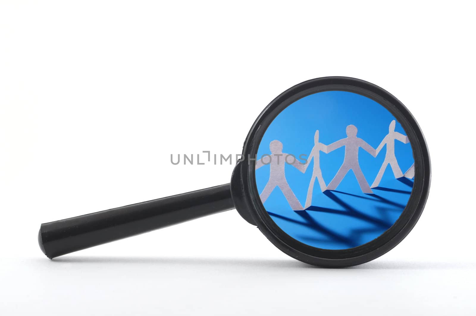 magnifying glass and team of paper man showing teamwork