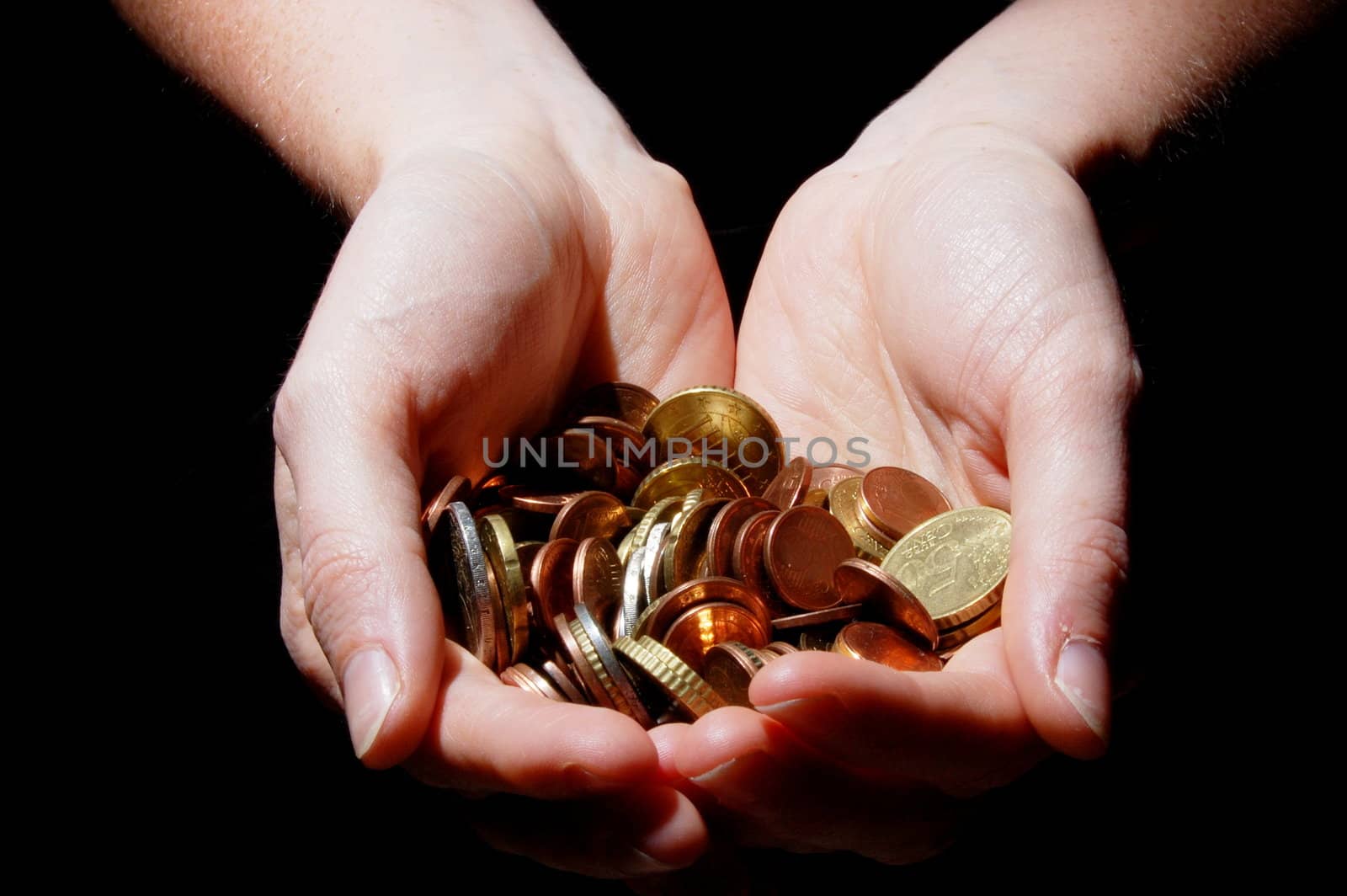 hands with money coins on a black background