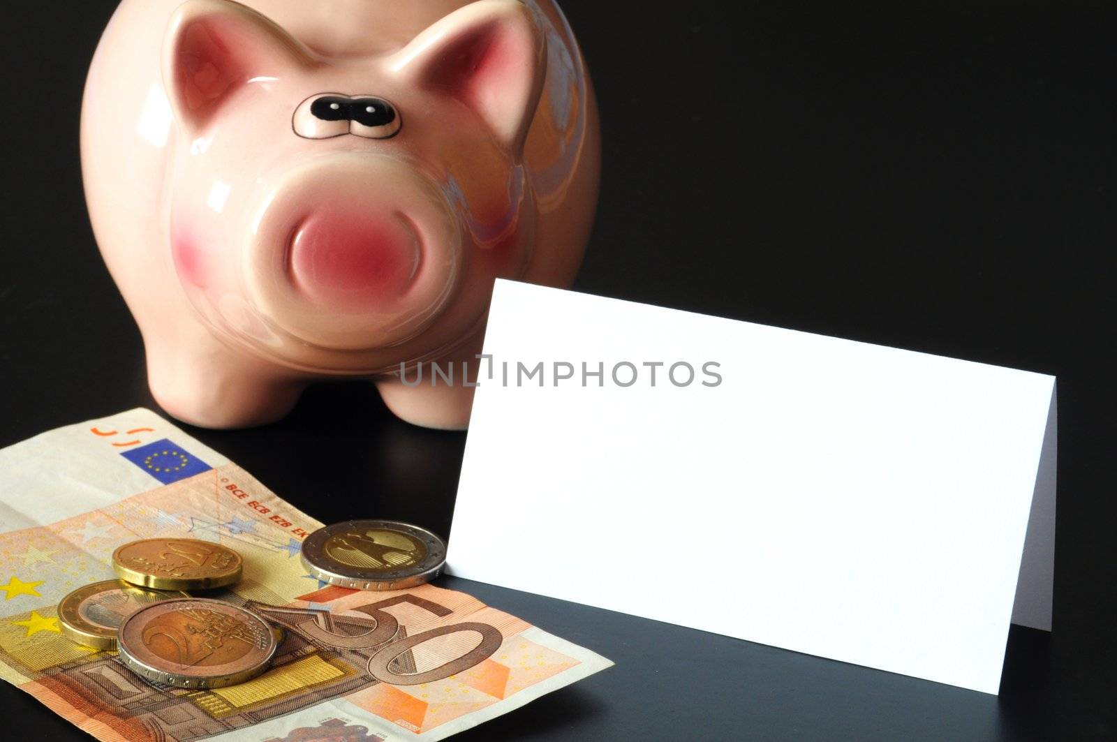 piggy bank and blank sheet of paper with copyspace for text message