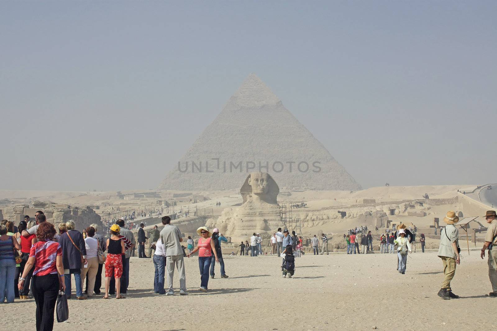 Egypt, Cairo, Giza, Sphinx and the pyramids in front of many tourists.