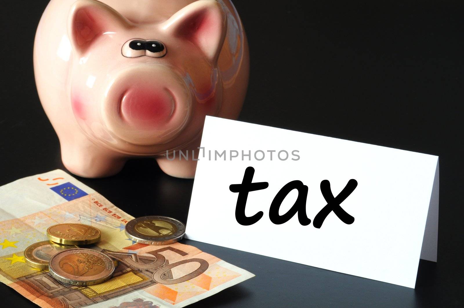 save tax concept with piggy bank and money on black