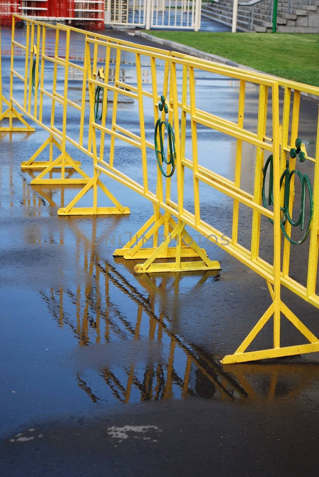 Bright yellow crowd control fence with reflection after rain
