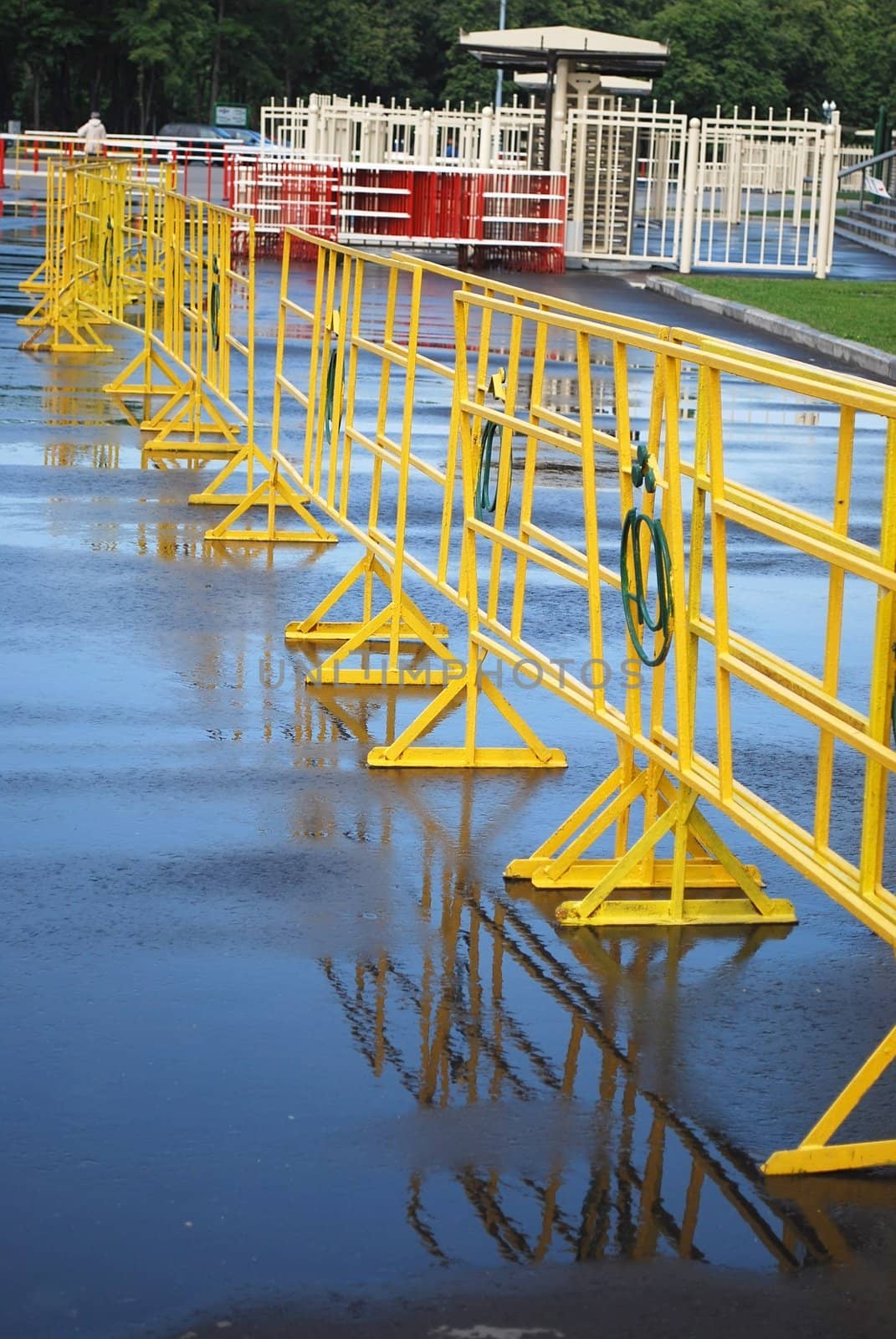 Bright yellow crowd control fence with reflection after rain