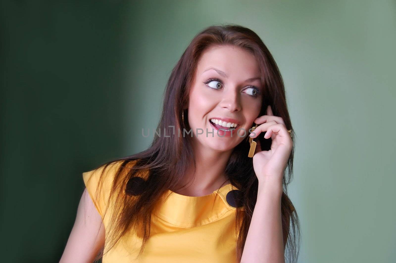 Happy girl talking on phone, dark background 