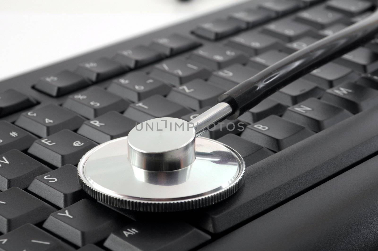 stethoscope on computer keyboard showing medical or pc support concept