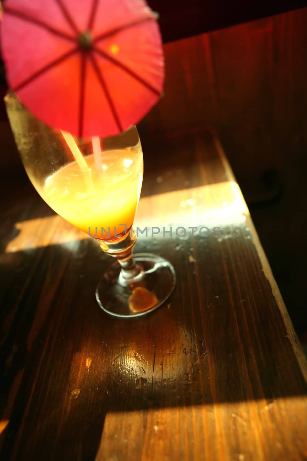 Goblet with Luminous Yellow Drink on Edge of the Table