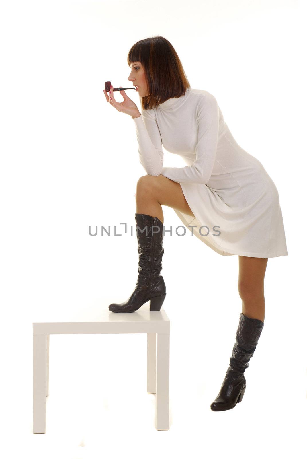 Pretty young woman with pipe dressed in white dress