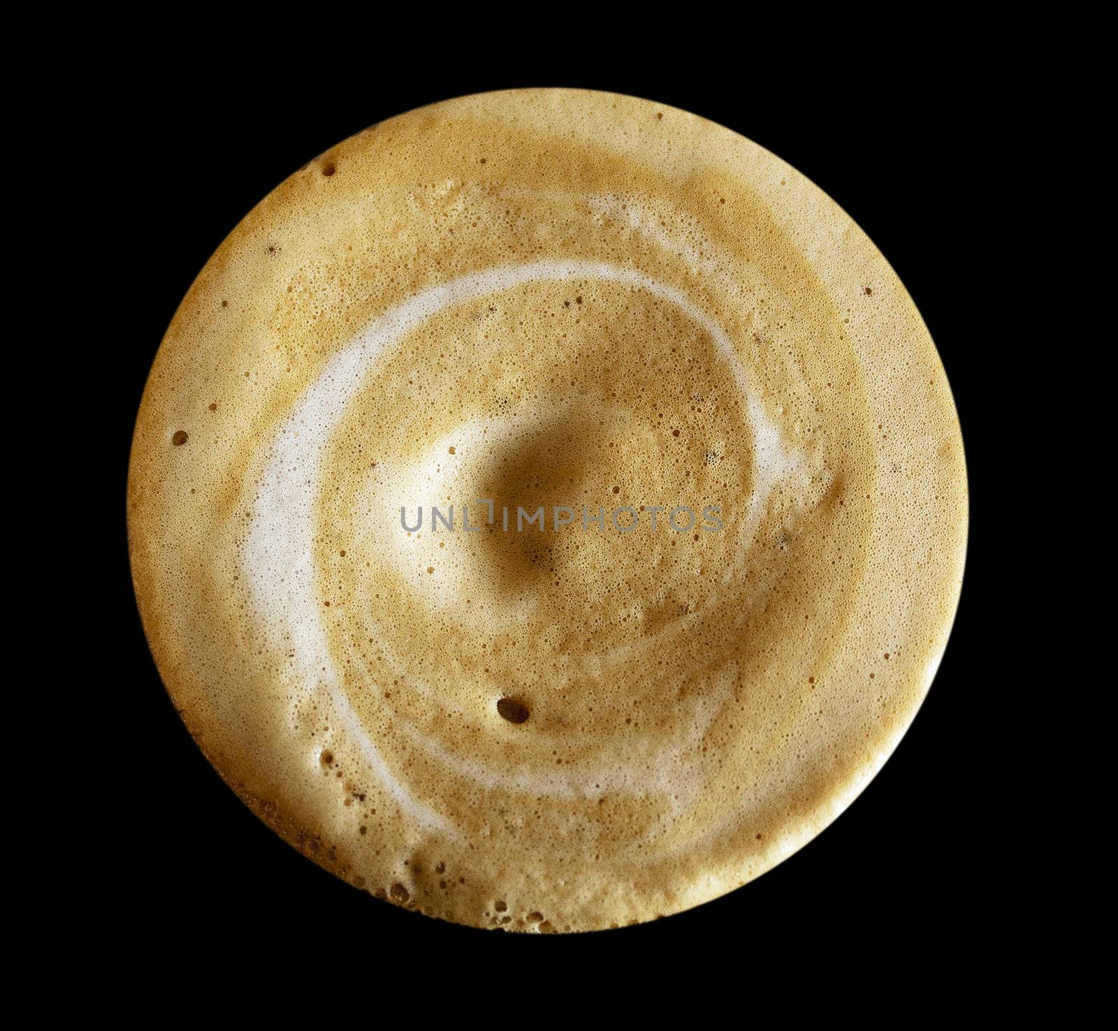 Close up of cappuccino foam isolated on a black background.