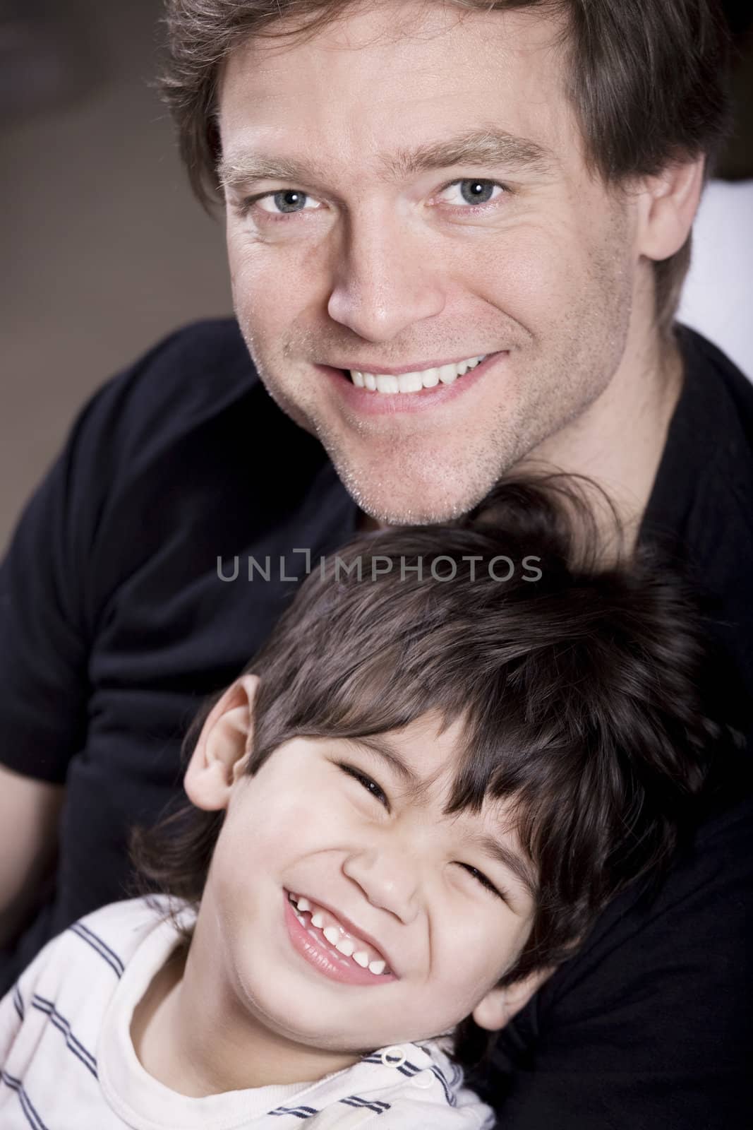 Father holding his son, smiling together