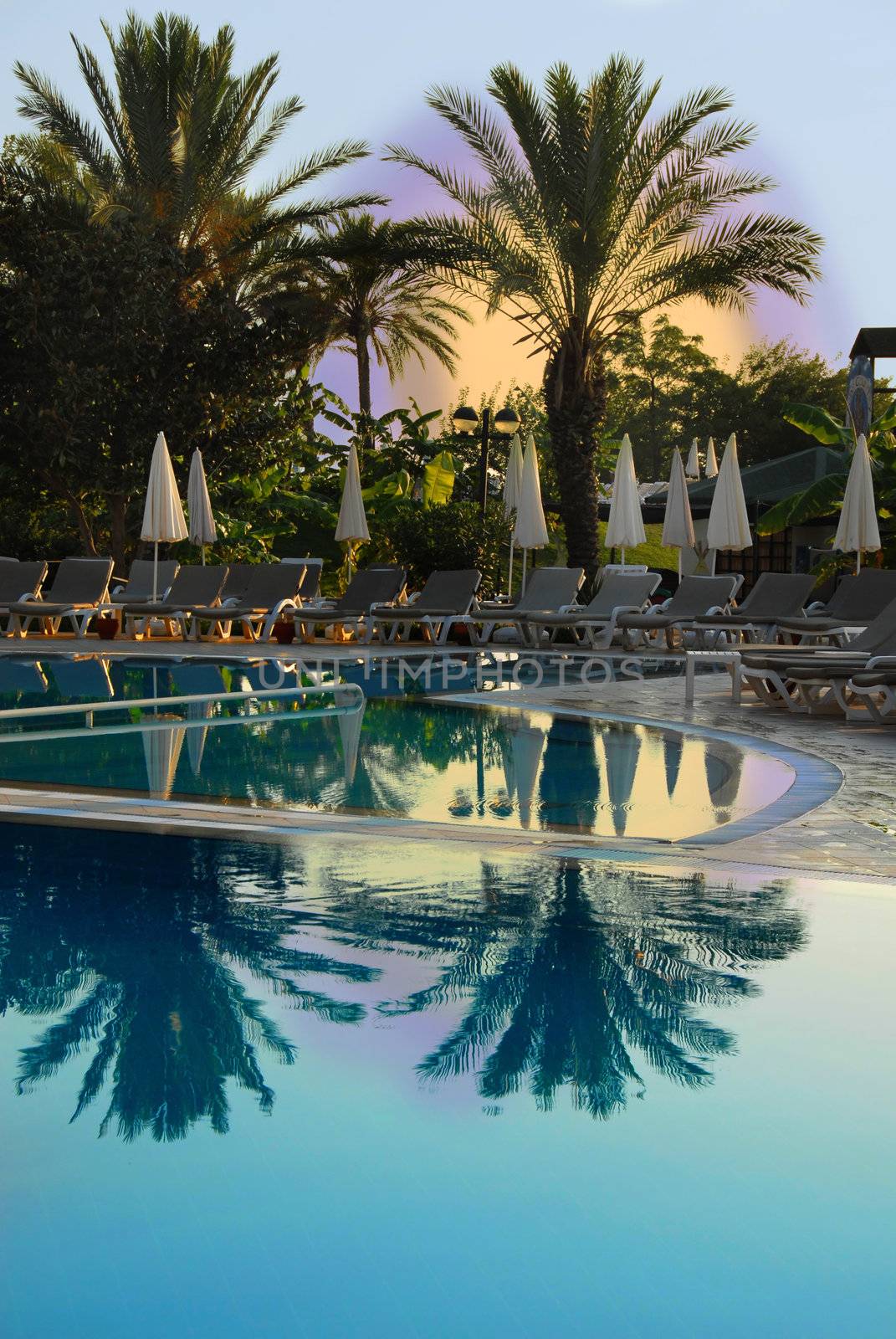 sun above swimming pool on Mediterranean seaside at summer resort in Turkey