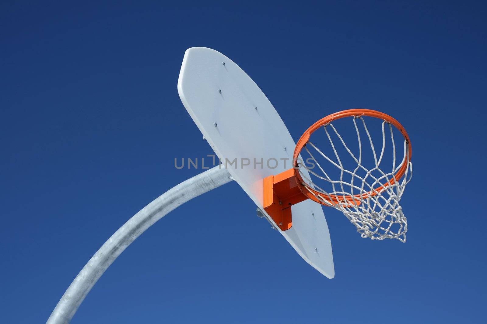Orange basketball hoop against the blue sky.