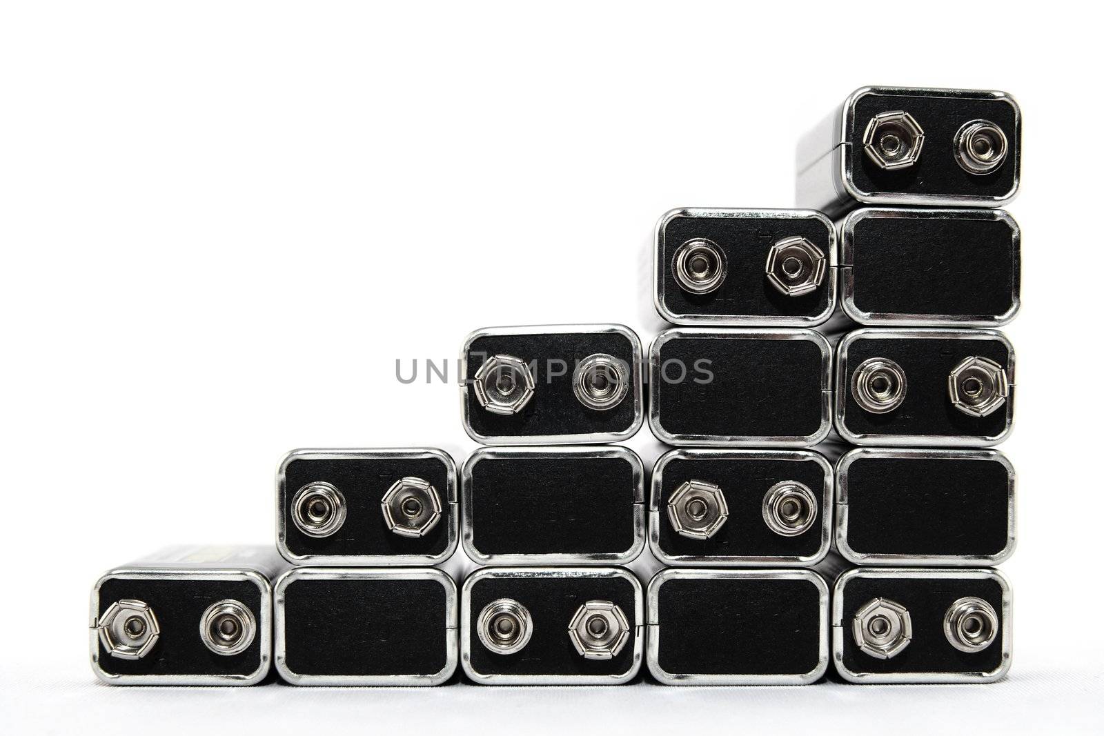 Nine volt batteries forming stairs, on white background.