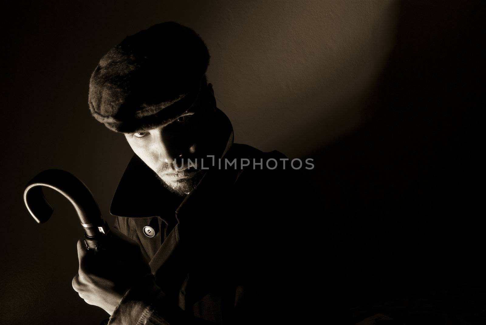 Sepia toned noir portrait of suspicious looking young man. Harsh highlights and shadows.