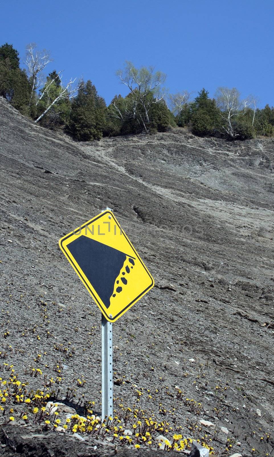 Falling rocks sign on the mountain slope by anikasalsera