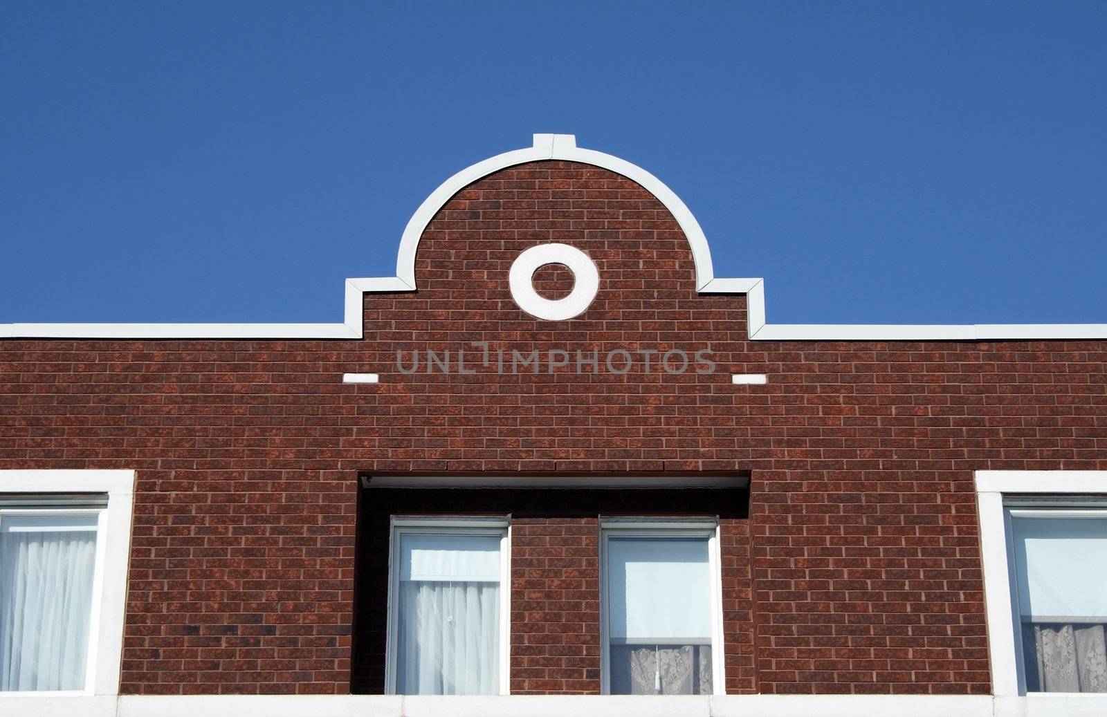 Facade and ornamental rooftop of a red brick house.