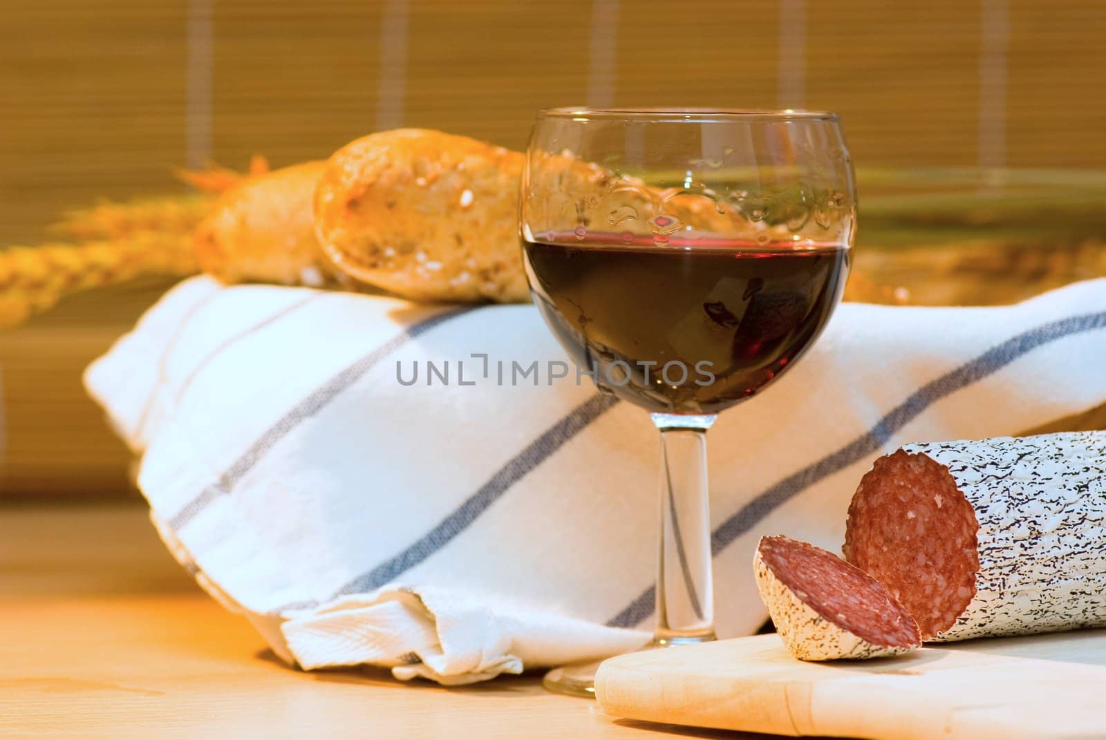 still life with red wine,sausage and bread roll