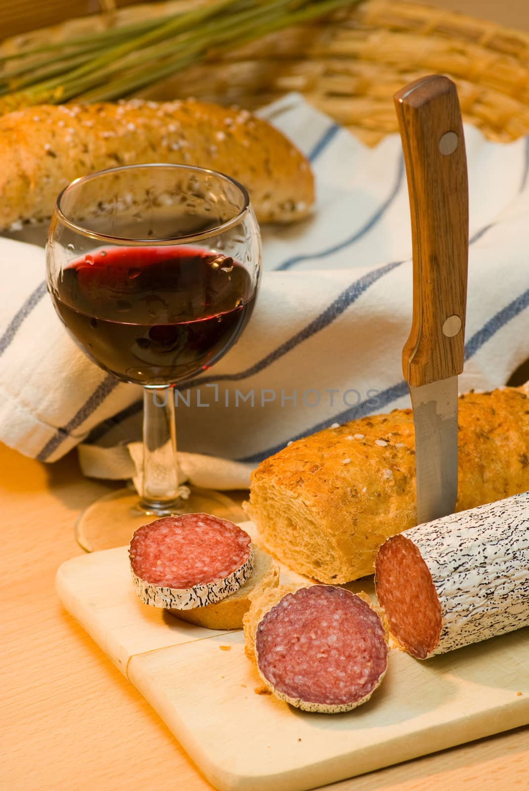 still life with red wine,sausage and bread roll