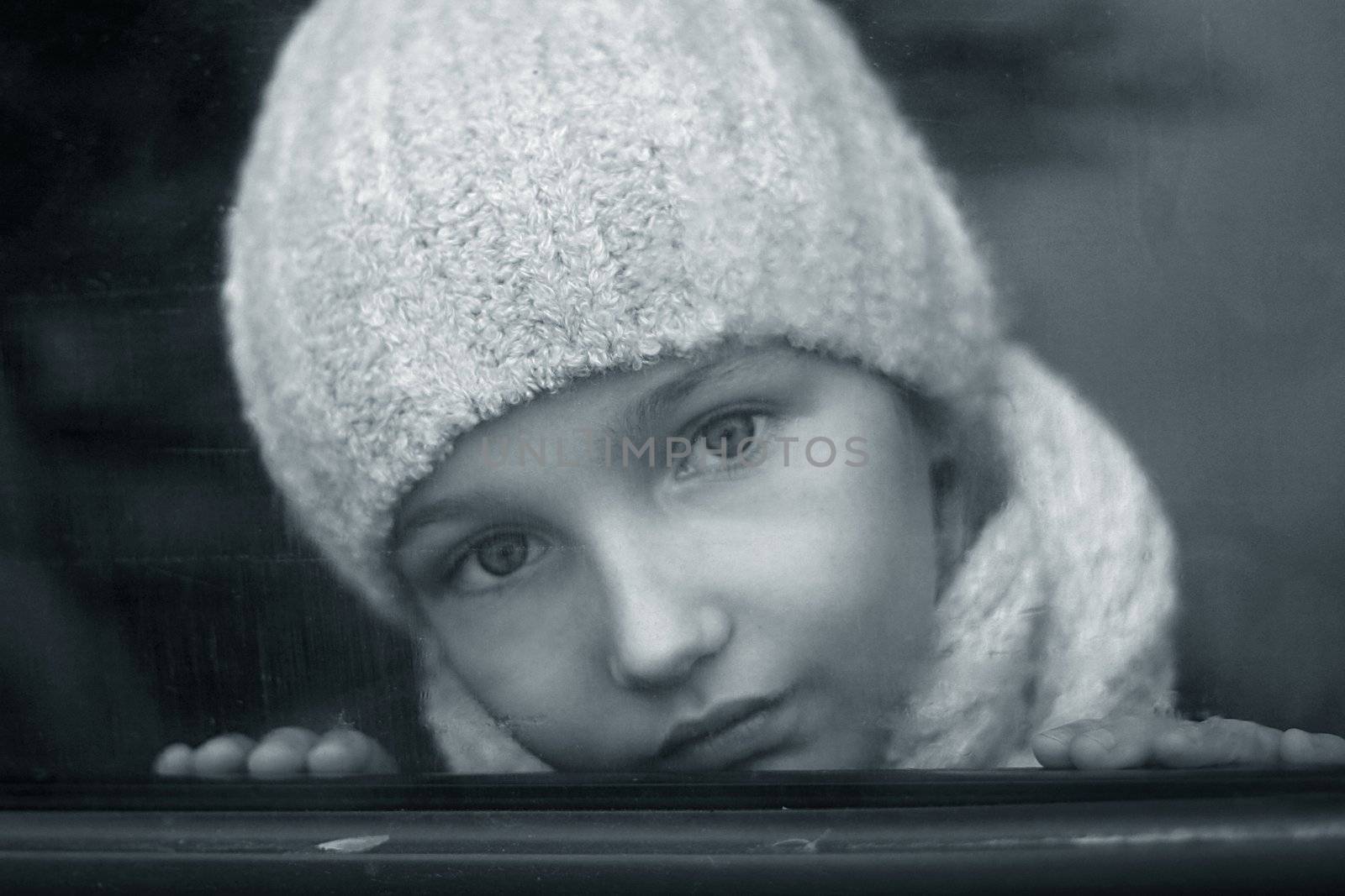 The nice girl behind glass of the automobile. b/w+blue tone