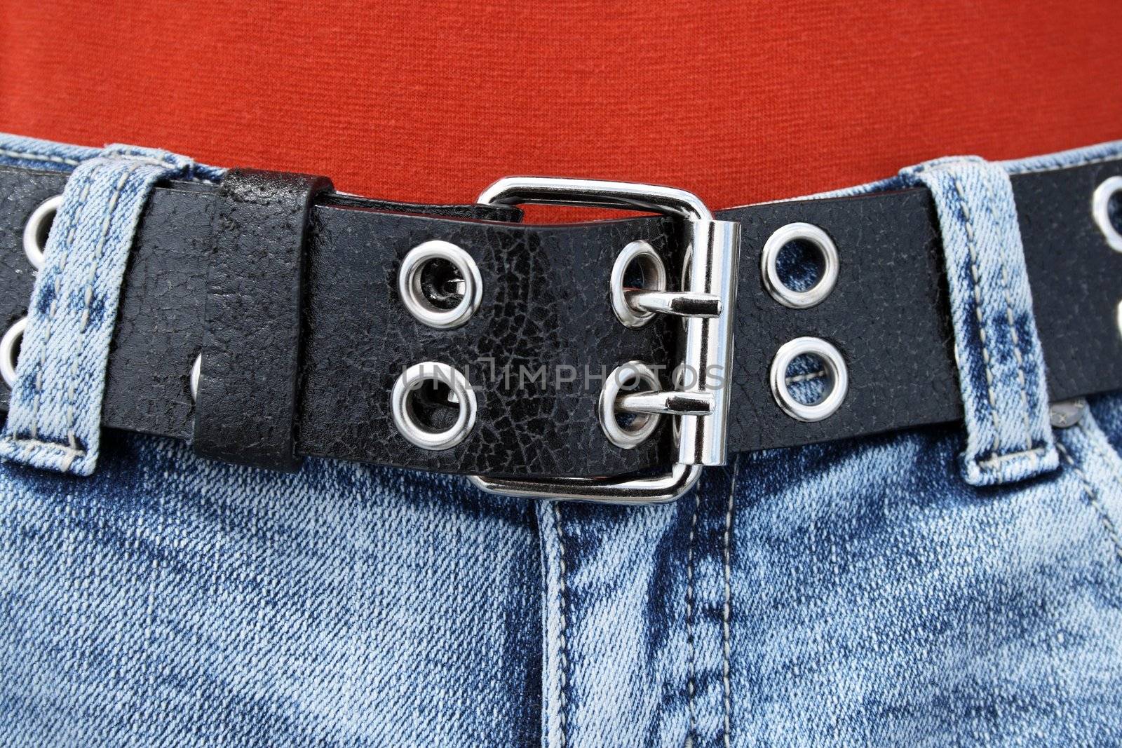 Black leather belt with metal buckle and blue jeans.