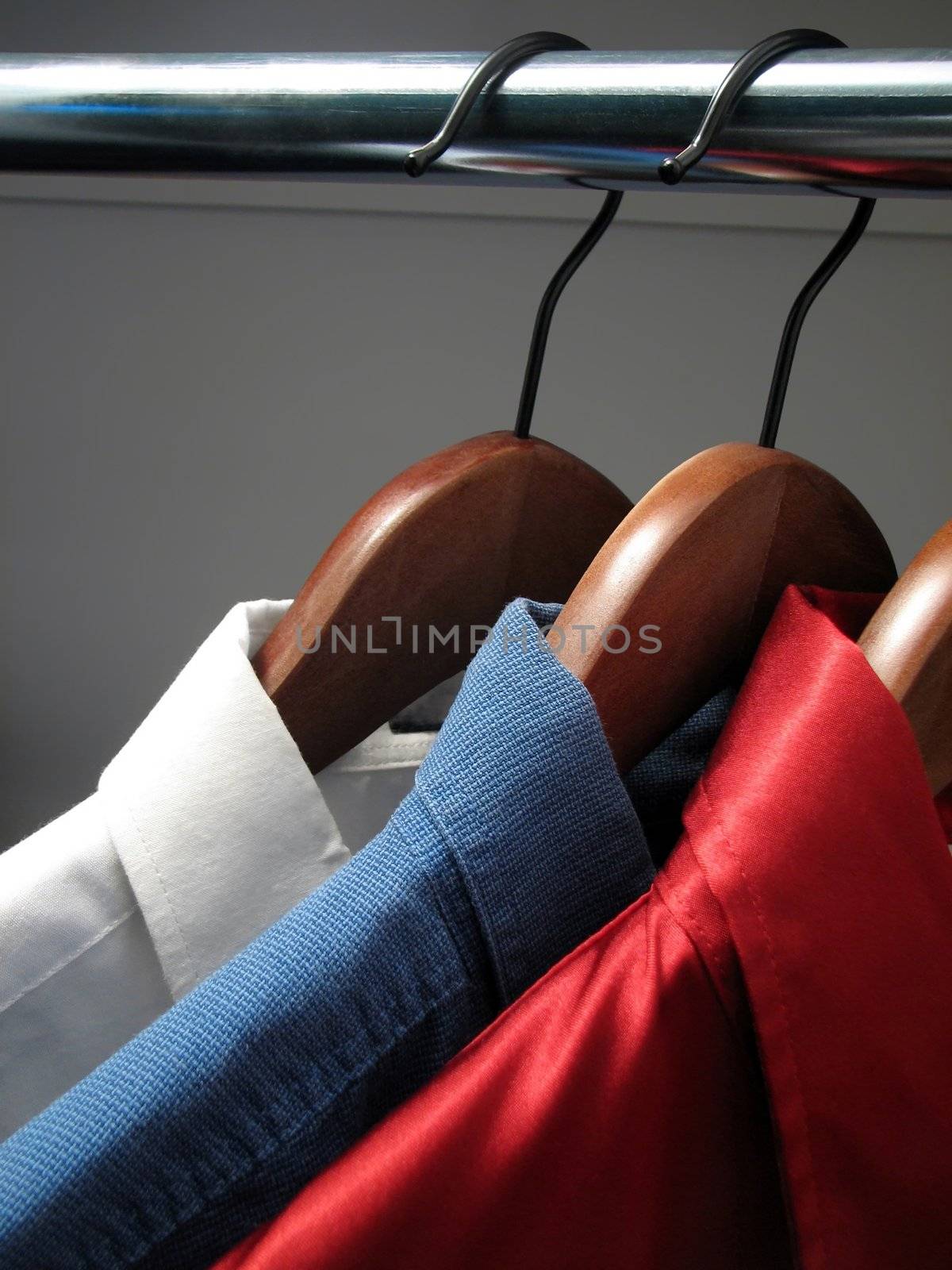 Colors of Russian flag: white, blue and red shirts on wooden hangers.