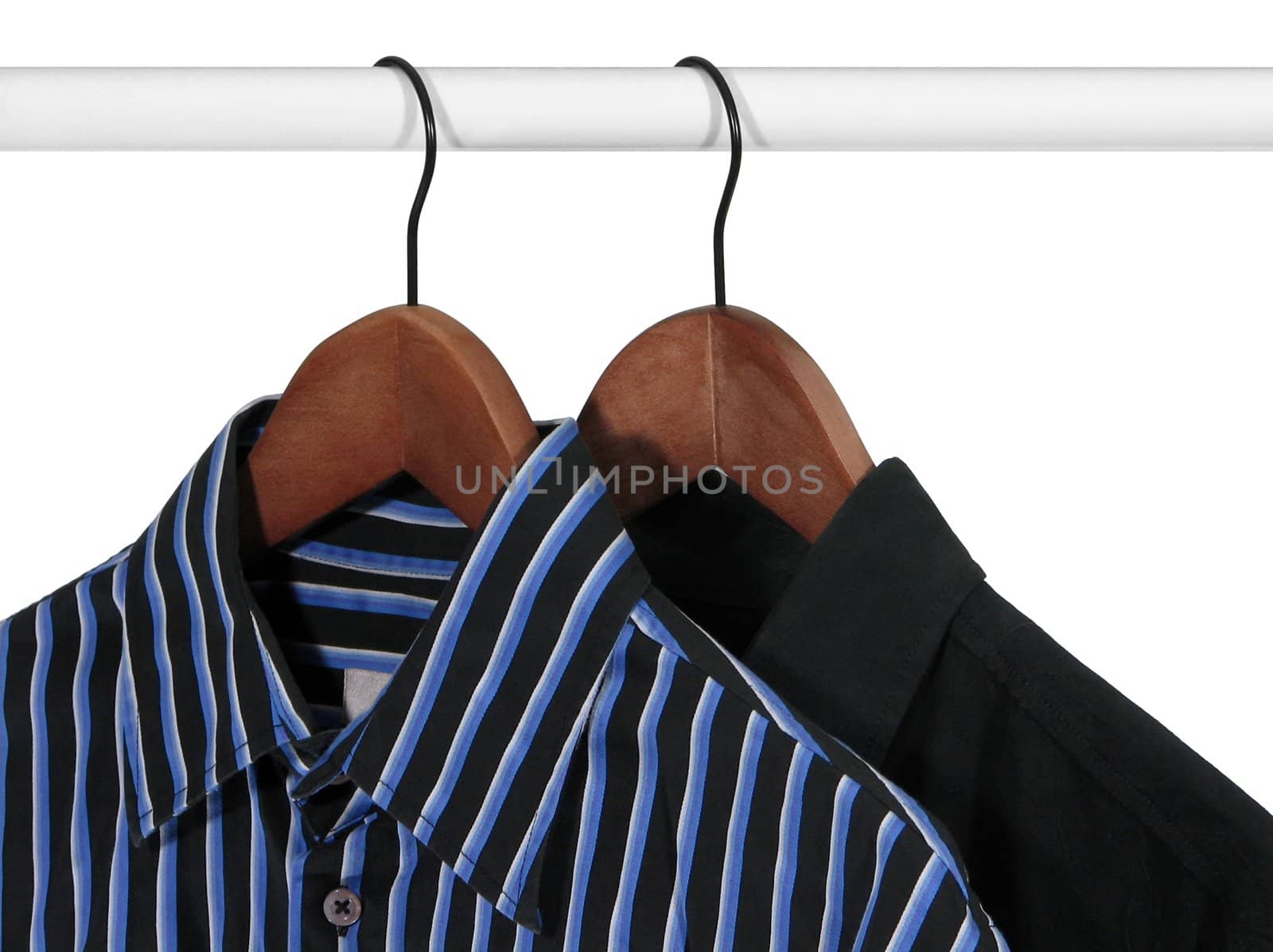 Closup of shirts on wooden hangers in a closet, on white background.