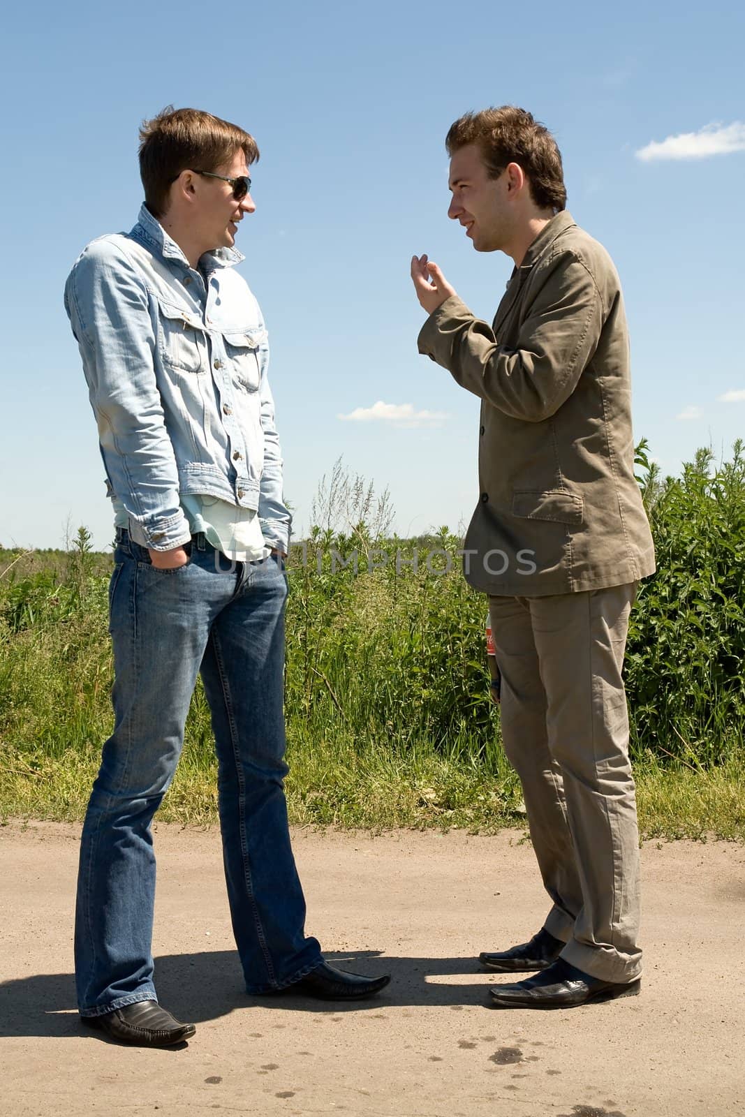 Friendly chat. Two young men talk outdoor.