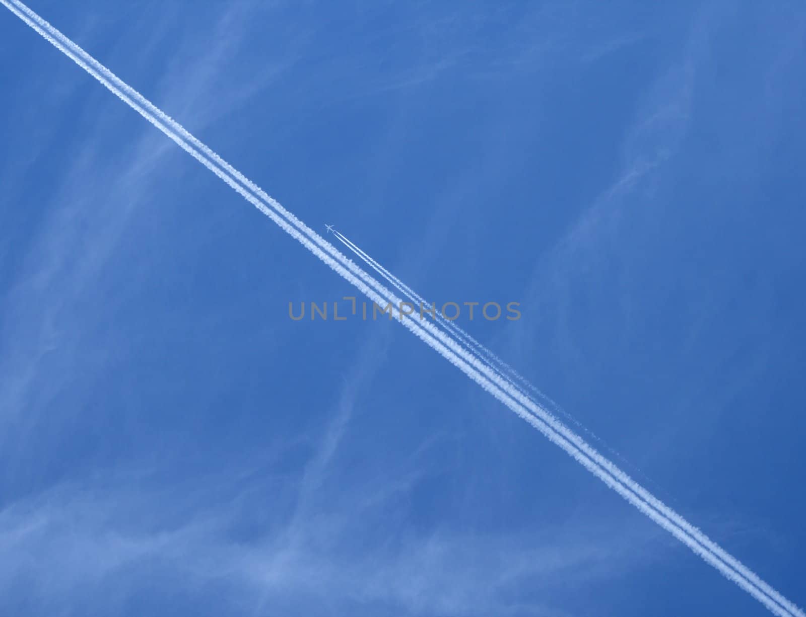 Trace of a jet airplane crossing the sky, and another plane flying near it.