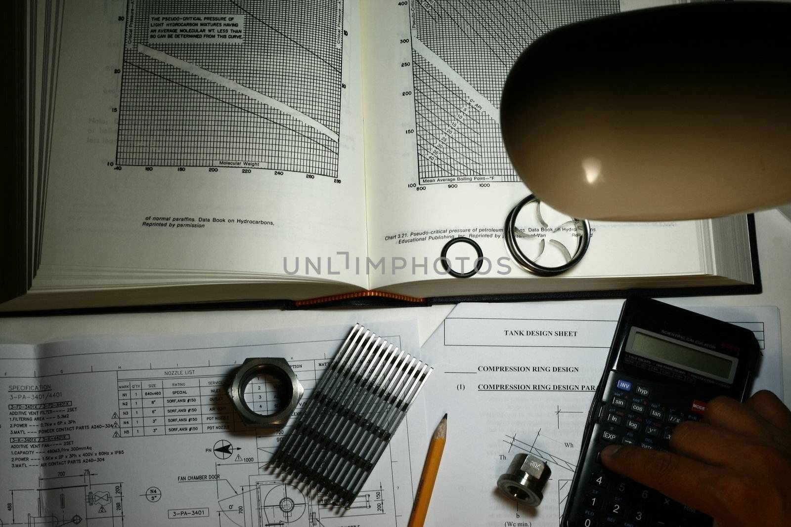 Engineer Working his Design concept, note intentional dark with study lamp