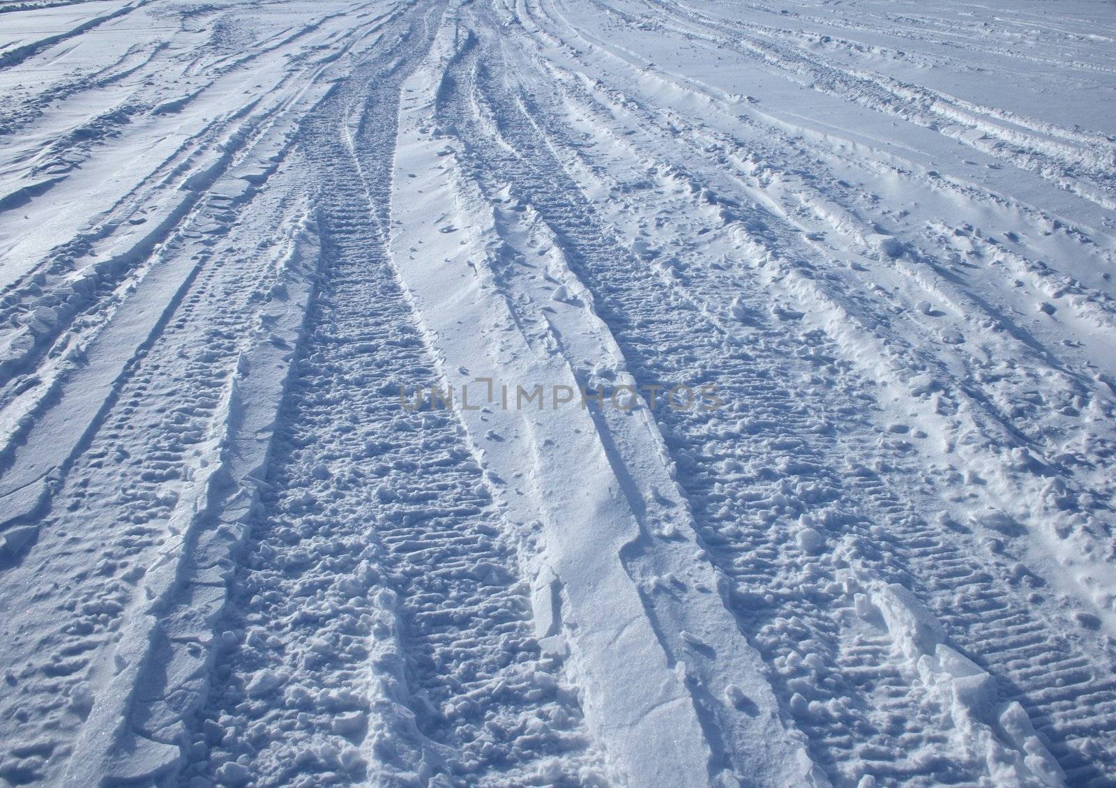 Winter road: vehicle tracks crossing the winter terrain.