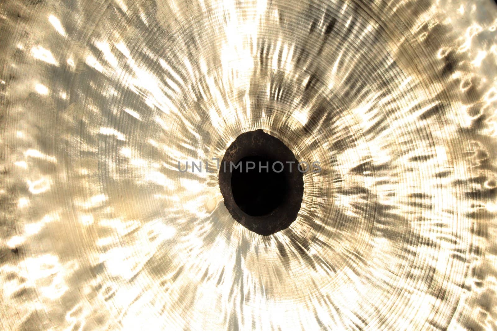 Black mysterious center of a Chinese cymbal. Shiny golden metallic texture.