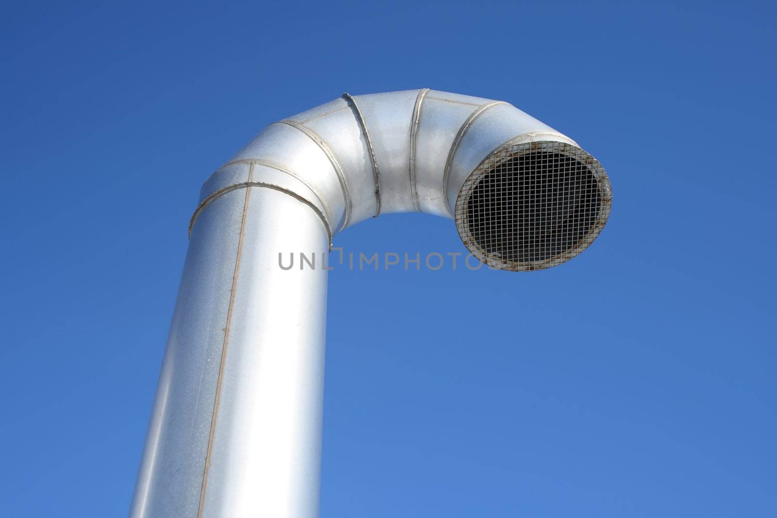 Shiny metallic ventilation pipe on a blue sky background.