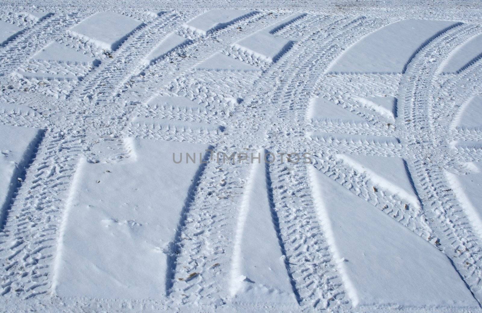 Tire tracks crossing the snowy terrain by anikasalsera