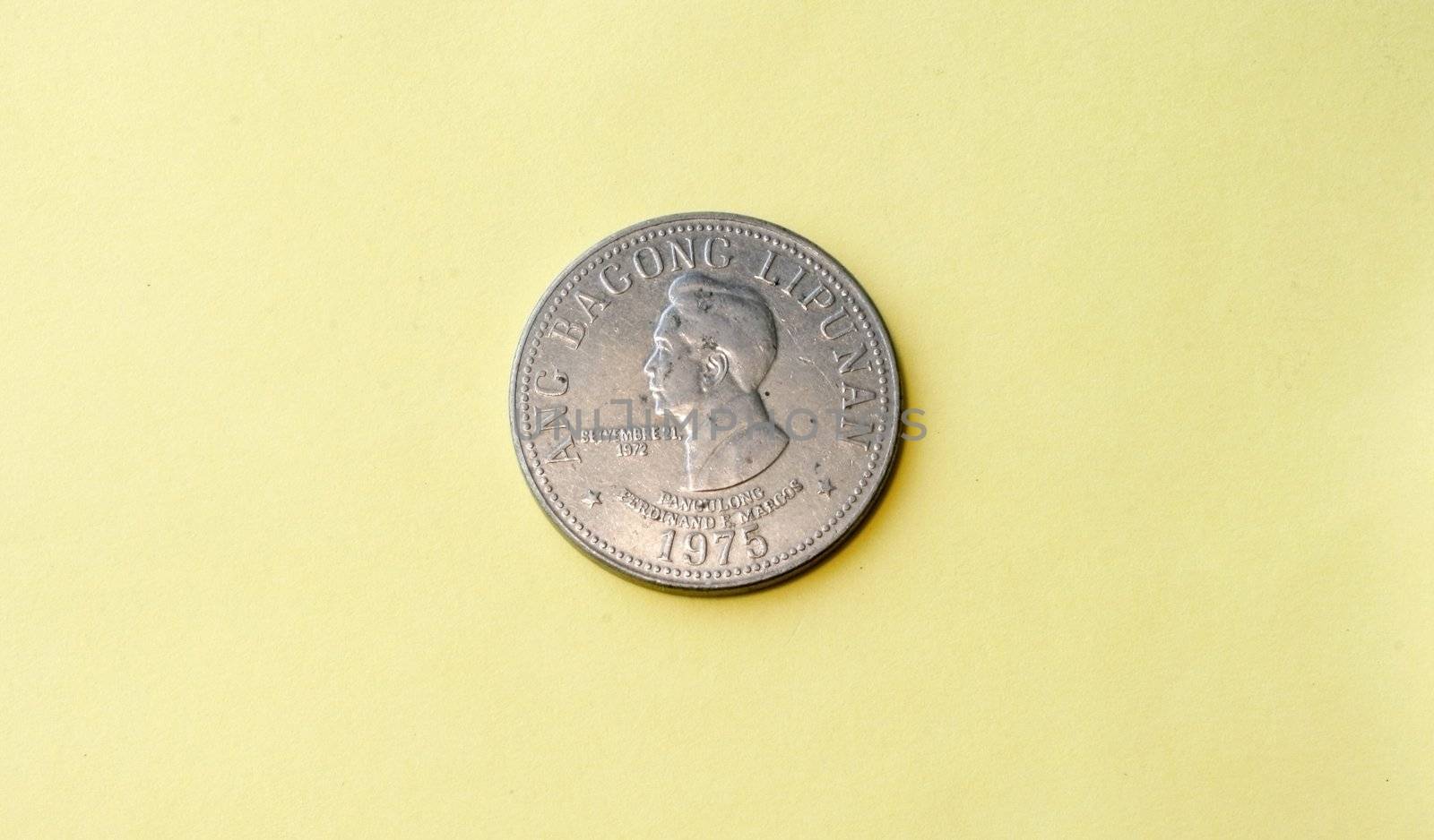 Old vintage coin circa 1972 depicting the face of Ferdinand Marcos 1972 - in a yellow background