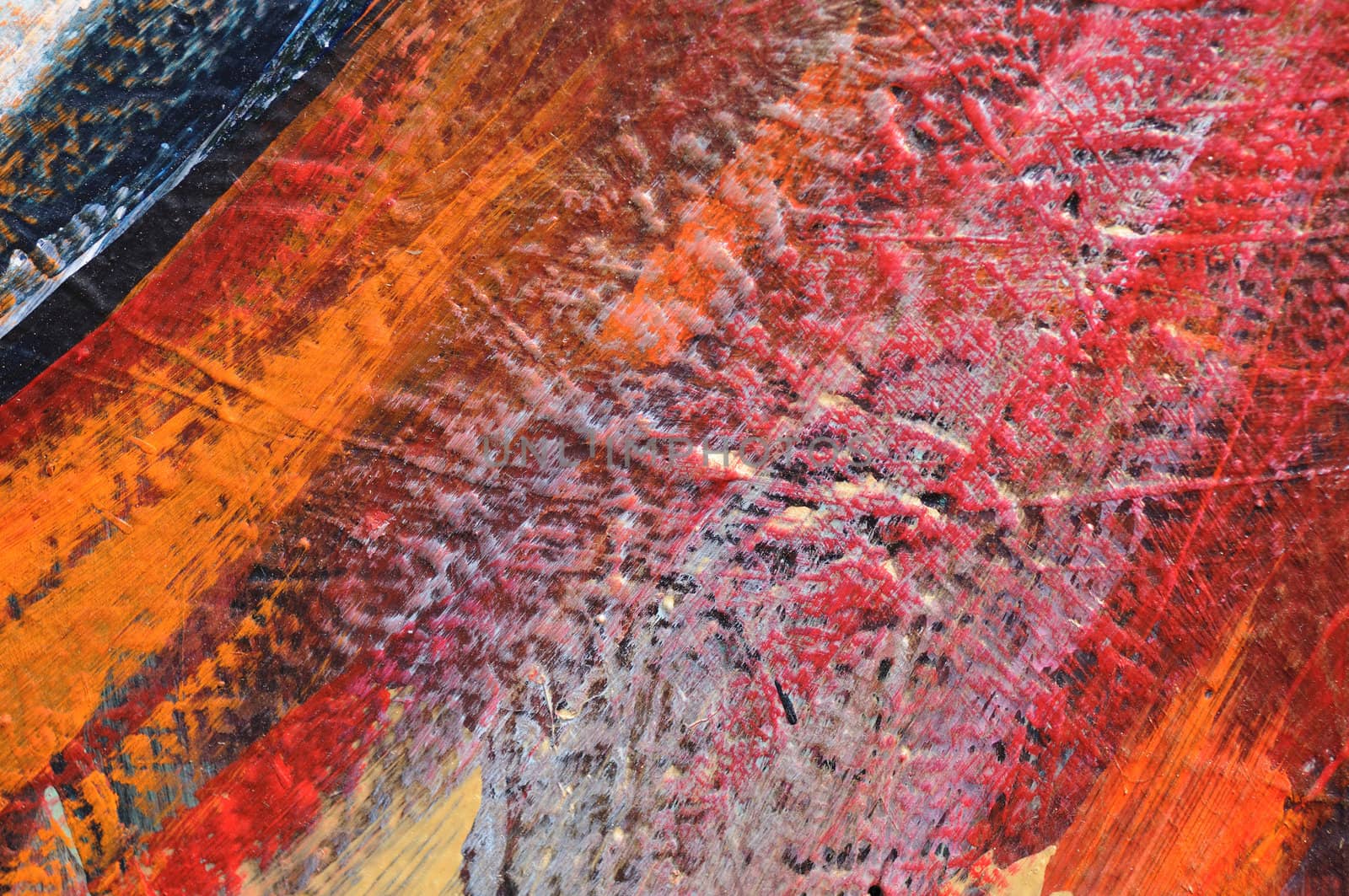 Bright orange, red, grey, and blue paint on a rough wall, a small detail from a large graffiti-style mural in Los Angeles, California.