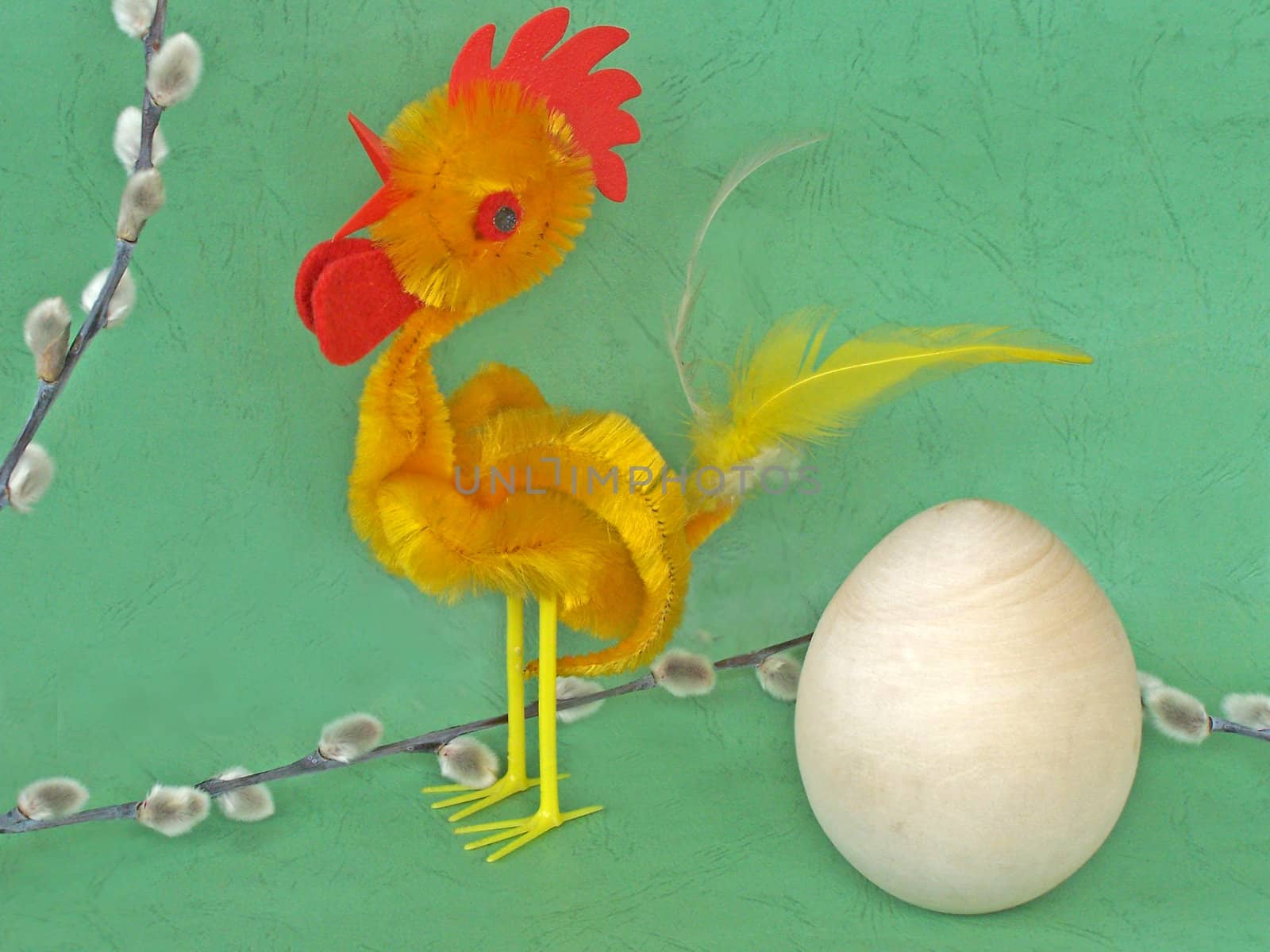 Toy rooster, wooden egg and pussy-willow branch. macro