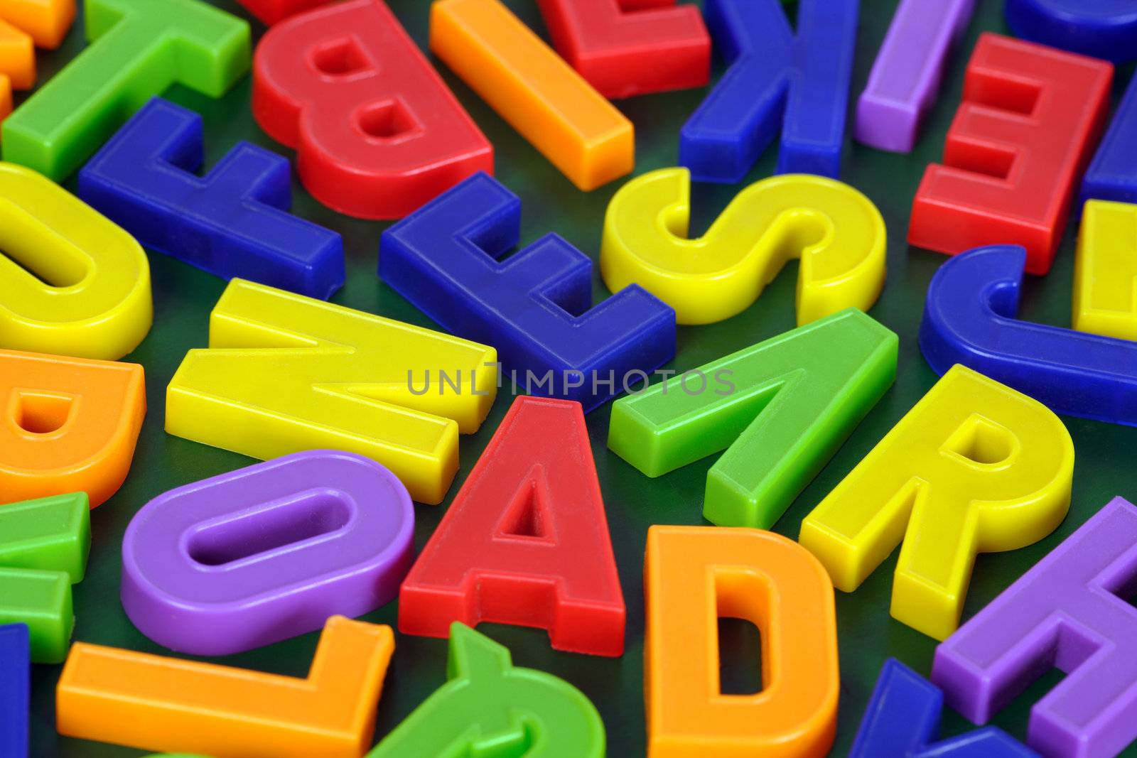 Background image of magnetic alphabet letters.  Focus is across the middle.
