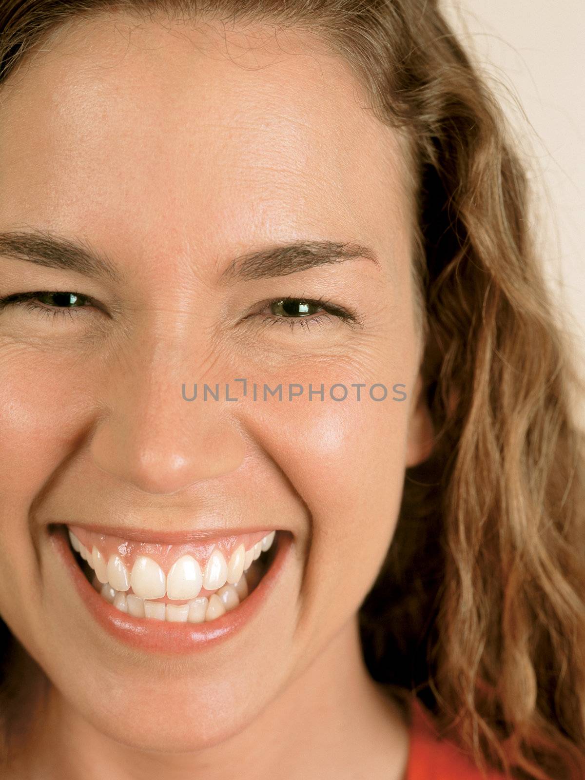 Closeup of a naturally beautiful woman with green eyes laughing.
